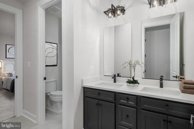 a bathroom with a double vanity sink toilet and shower