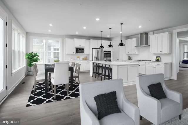 a living room with stainless steel appliances furniture and a view of kitchen