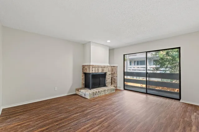 wooden floor fireplace and windows in an empty room