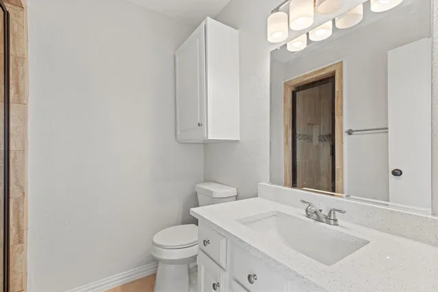 a bathroom with a toilet a sink and mirror