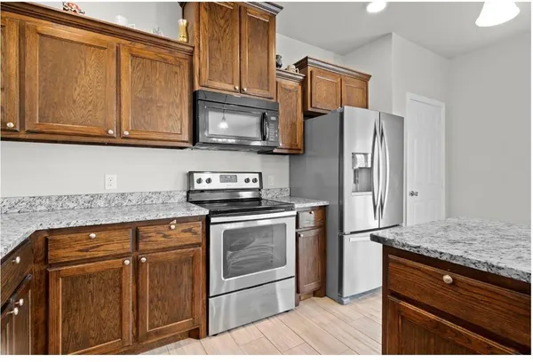 a kitchen with stainless steel appliances granite countertop a refrigerator stove and microwave