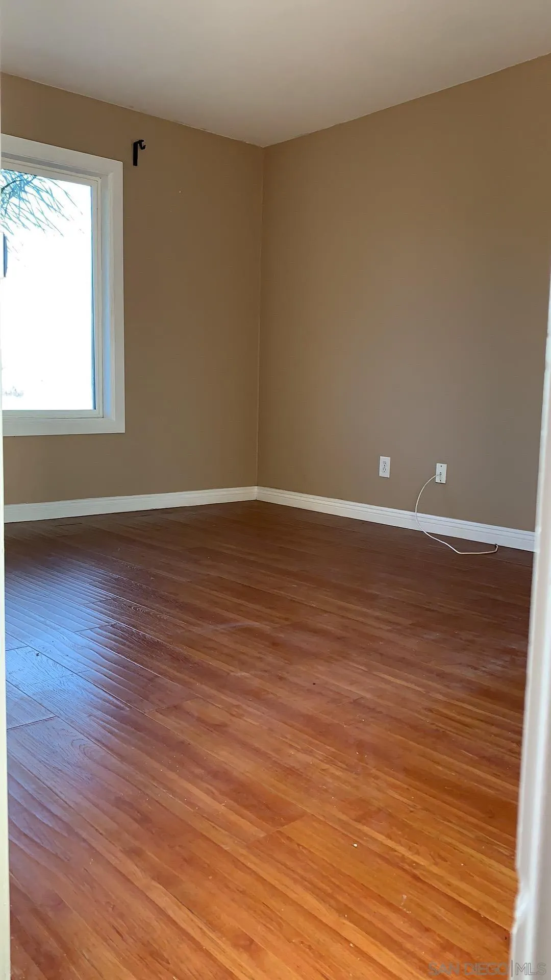 13605 Acton Avenue Poway, CA 92064 - Photo 12 of 18 a view of an empty room with wooden floor and a window