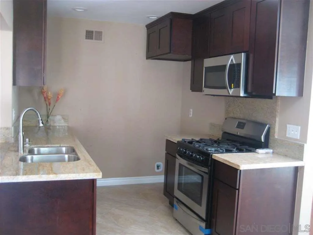 13605 Acton Avenue Poway, CA 92064 - Photo 7 of 18 a kitchen with stainless steel appliances granite countertop a sink stove and microwave