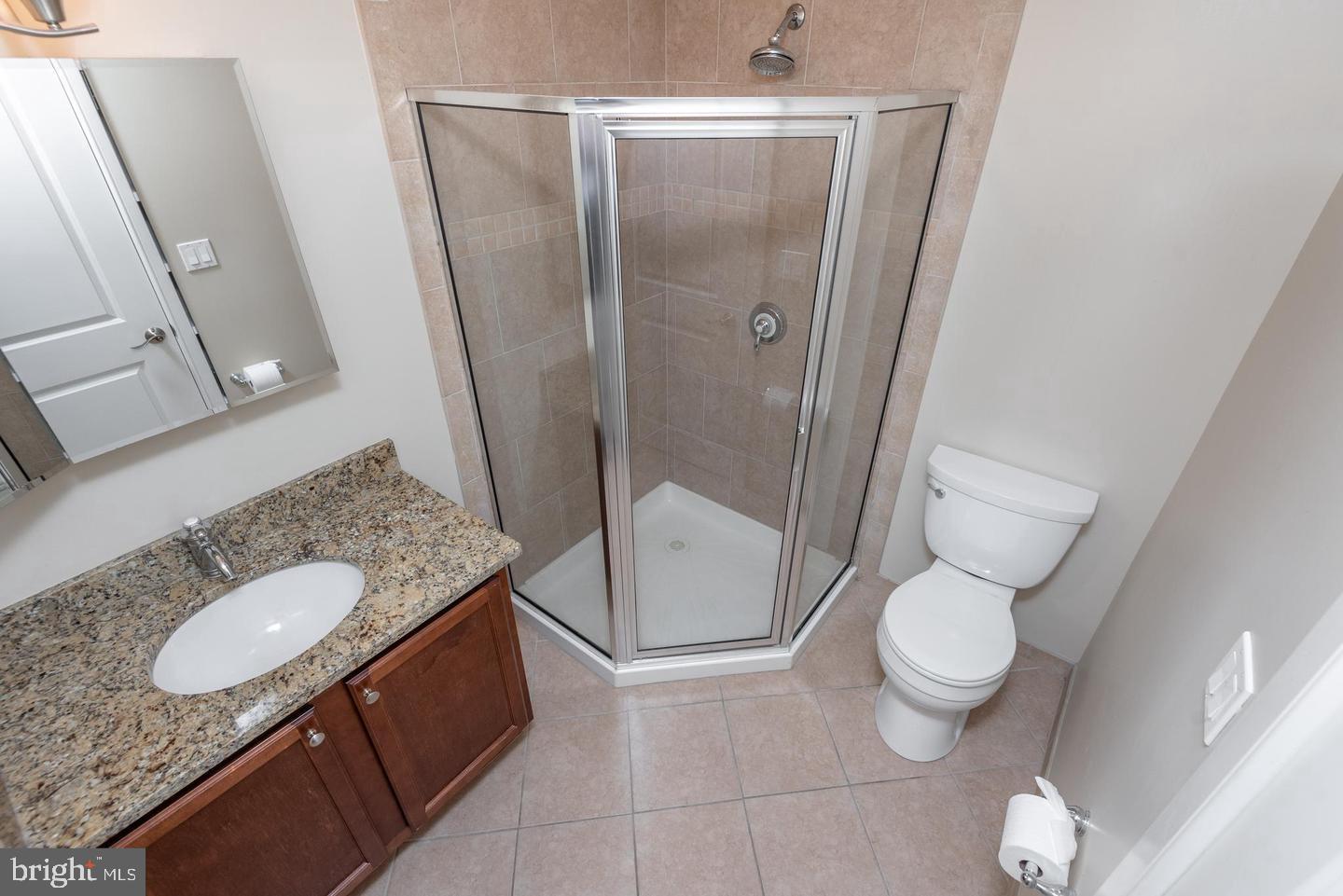4300 Spruce Street, Unit A102 Philadelphia, PA 19104 - Photo 12 of 16 a bathroom with a granite countertop sink toilet and shower