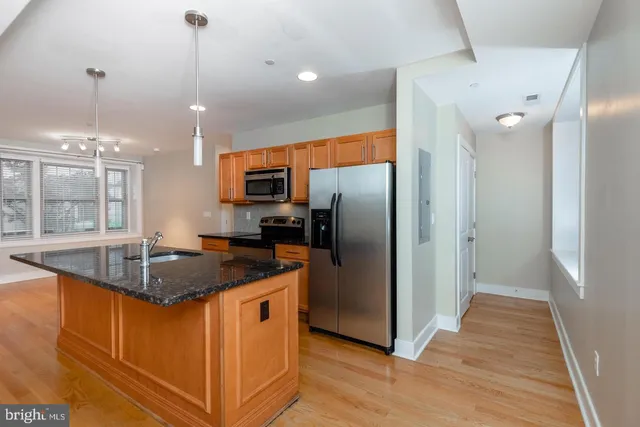 a kitchen with stainless steel appliances granite countertop a sink a refrigerator and a granite counter tops