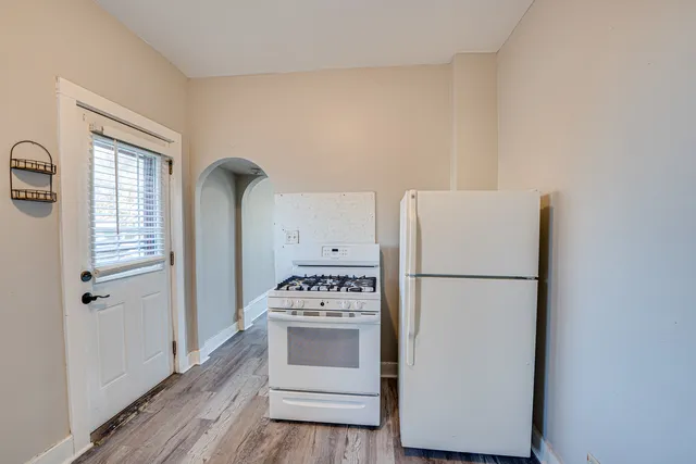a white refrigerator freezer and a stove sitting inside of a kitchen
