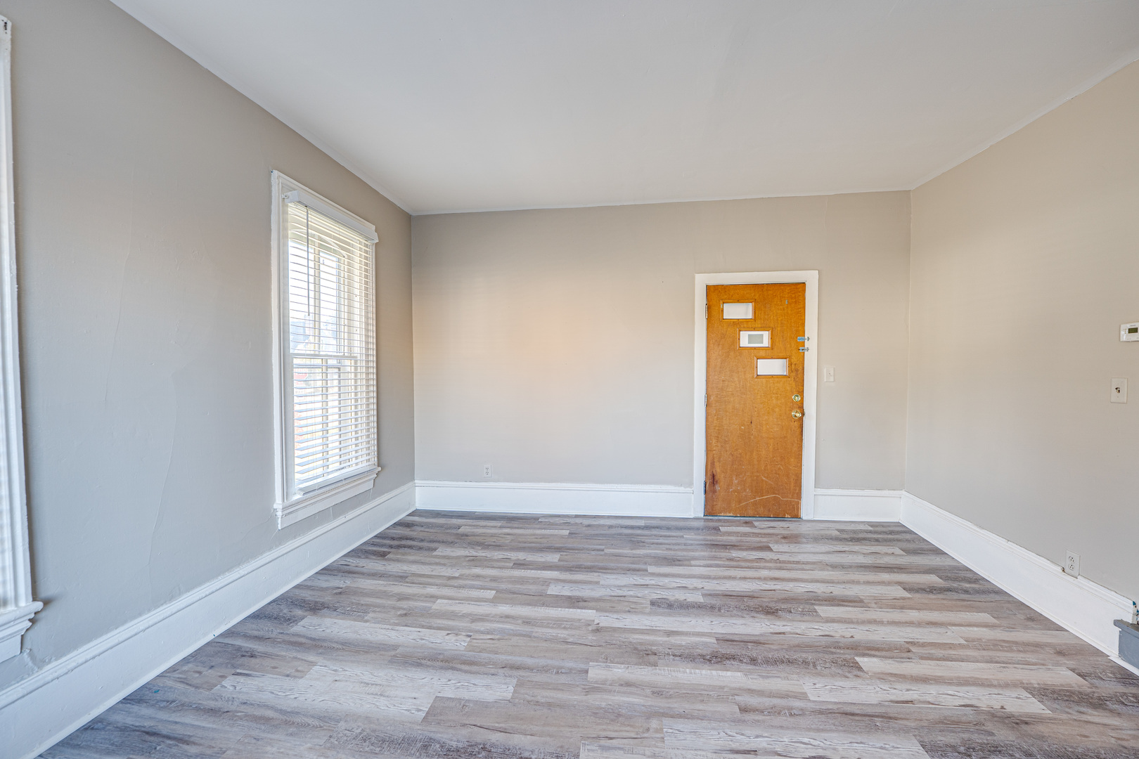79 South 4th Street, Unit 2 Aurora, IL 60505 - Photo 5 of 10 a view of an empty room with wooden floor and a window