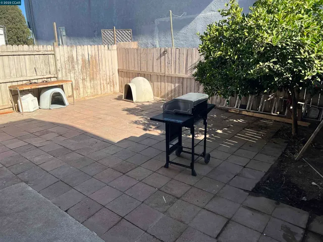 a view of a patio with table and chairs and couches with wooden fence