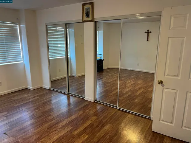 an empty room with wooden floor and a fireplace