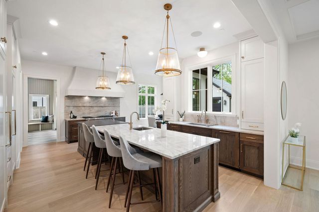 a large kitchen with granite countertop lots of counter space dining table and stainless steel appliances