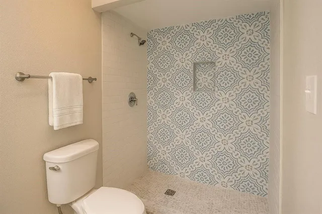 a bathroom with a toilet and shower