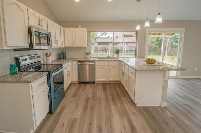a kitchen with sink a microwave and cabinets