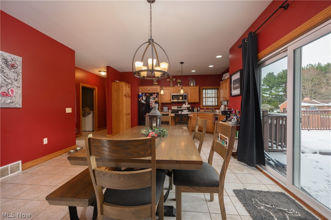 806 Forrest Ridge Drive Dover, OH 44622 - Photo 14 of 36 Dining area featuring light tile patterned floors and hanging lights