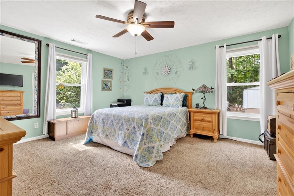 3771 Castleberry Road Cumming, GA 30040 - Photo 23 of 69 a bedroom with a large bed and a chandelier fan