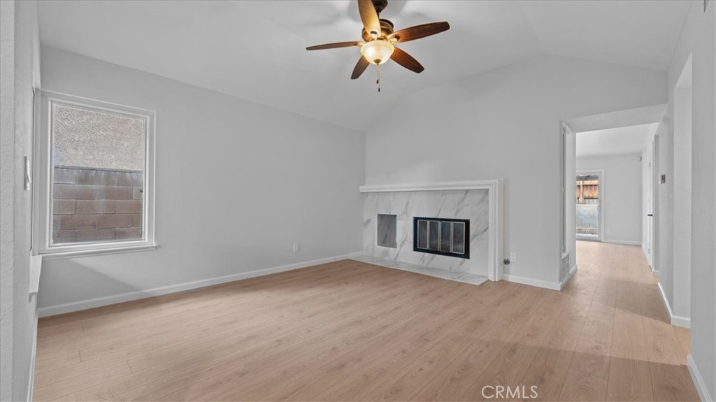 10720 Springfield Drive Rancho Cucamonga, CA 91730 - Photo 5 of 35 an empty room with fireplace and ceiling fan