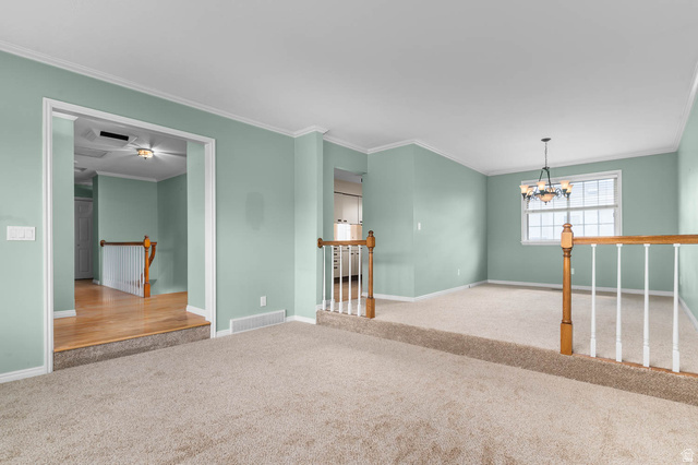 1822 East 9800th Street South Sandy, UT 84092 - Photo 25 of 38 Unfurnished room featuring a chandelier, light colored carpet, and ornamental molding