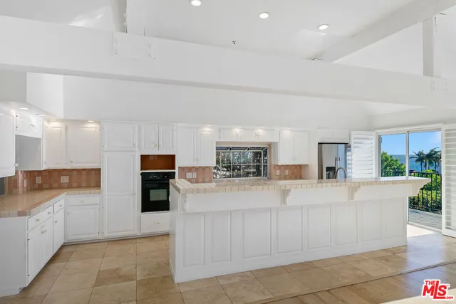 a kitchen with stainless steel appliances granite countertop a sink and a stove