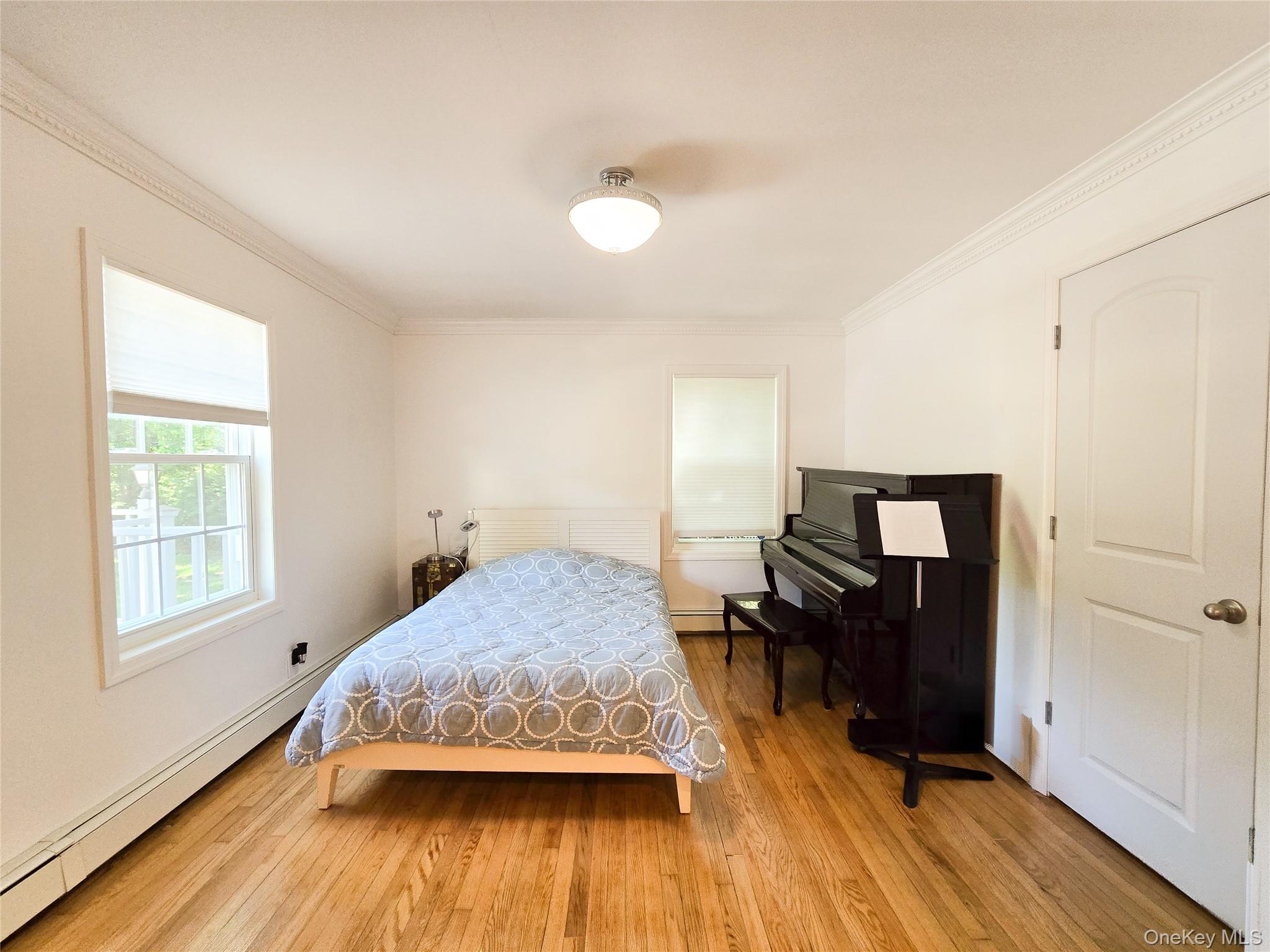 249 Cold Spring Road Syosset, NY 11791 - Photo 8 of 28 a bedroom with a bed and wooden floor