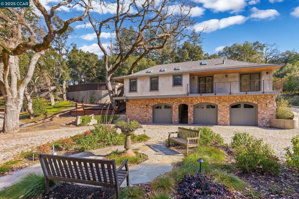 a front view of a house with patio furniture and a tree