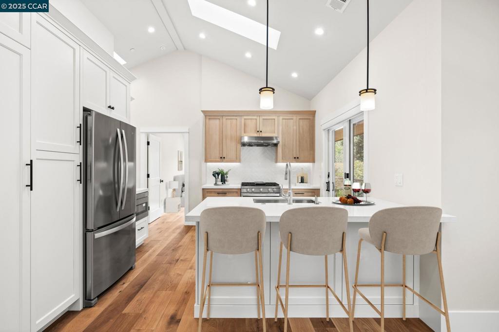 100 Moraga Way Orinda, CA 94563 - Photo 16 of 48 a kitchen with granite countertop a center island a refrigerator and a dining table