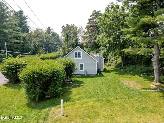 a house is sitting in middle of the green field