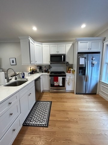 a large kitchen with stainless steel appliances granite countertop a stove top oven a sink and dishwasher