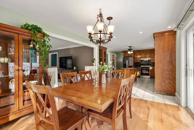 a dining room with furniture a chandelier and wooden floor