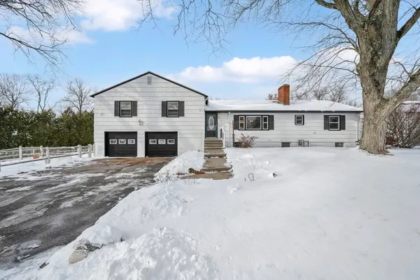 a view of a house with a yard covered in snow