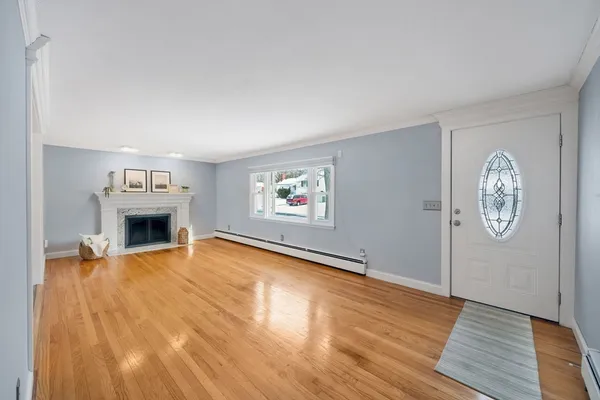 a view of a livingroom with wooden floor and a fireplace