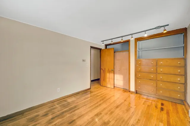 a view of empty room with wooden floor and cabinet
