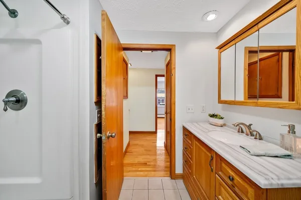 a bathroom with a granite countertop sink and a mirror
