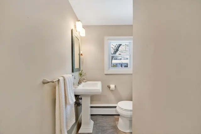 a bathroom with a toilet a sink and mirror