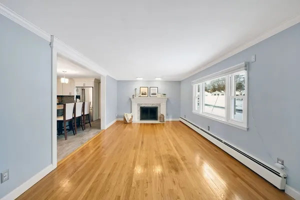 a view of empty room with wooden floor and fireplace