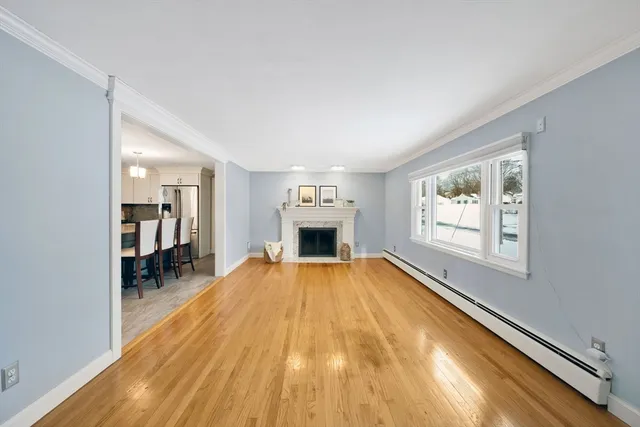a view of empty room with wooden floor and fireplace