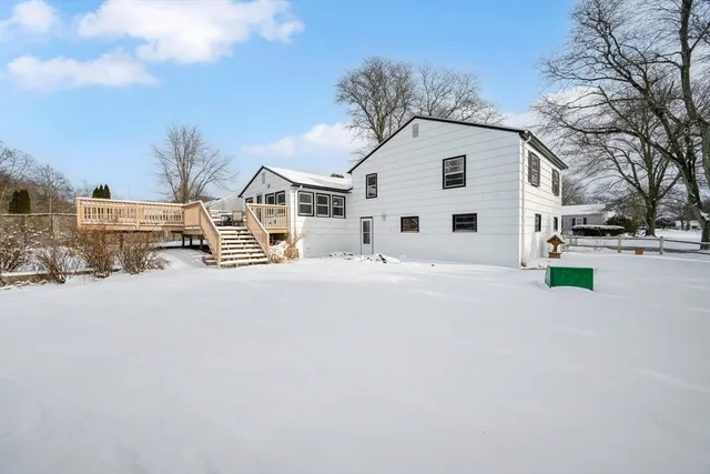 a view of white house with a yard covered in snow