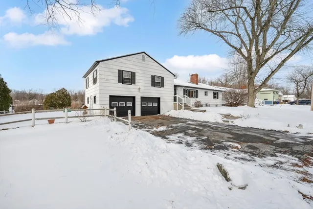 a view of a white house with a yard covered in snow
