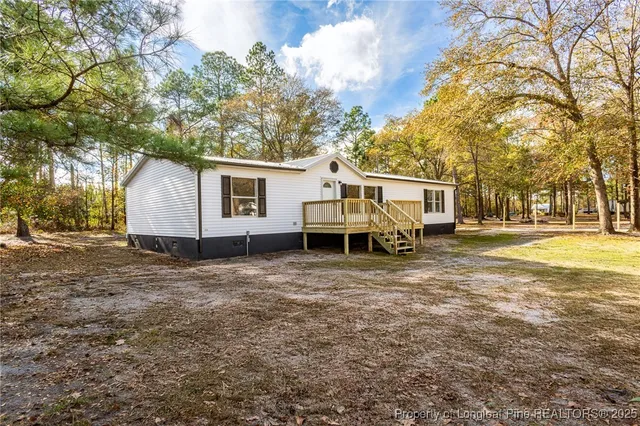 a white house that has a tree in front of it