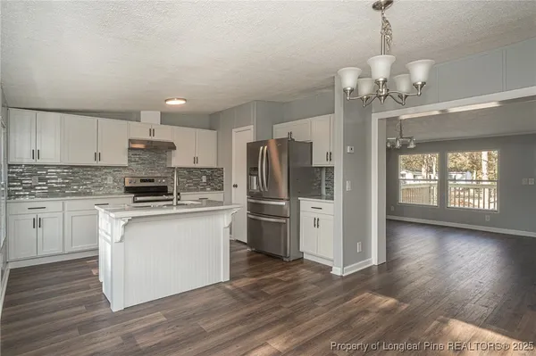 a kitchen with stainless steel appliances a refrigerator sink and stove