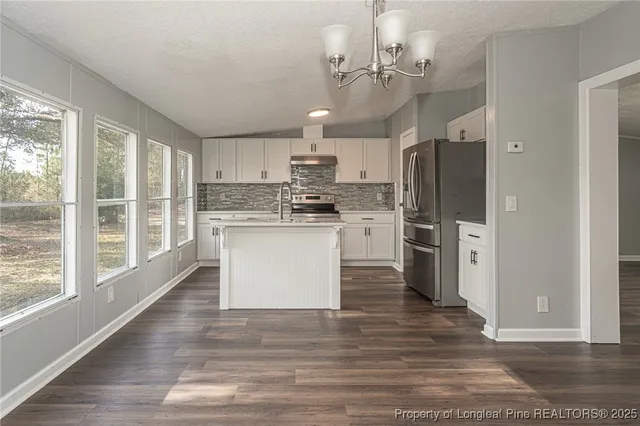 a kitchen with stainless steel appliances a refrigerator sink and cabinets