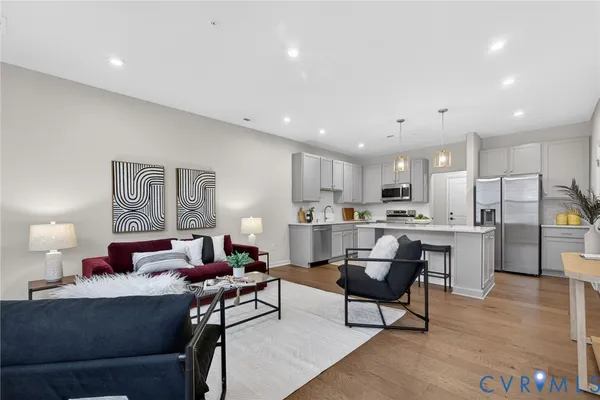 a living room with stainless steel appliances kitchen island granite countertop furniture and a view of kitchen