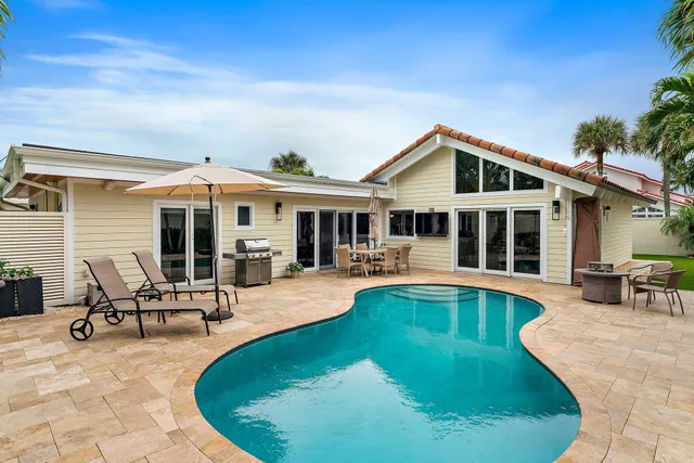 a view of a house with swimming pool and sitting area
