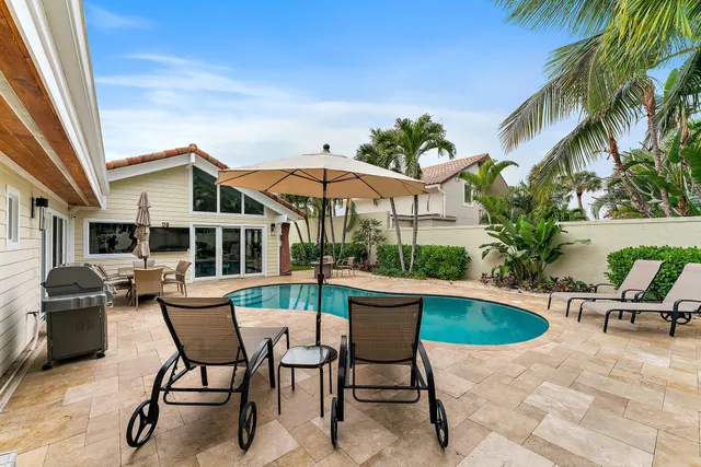 a view of a house with backyard sitting area and swimming pool