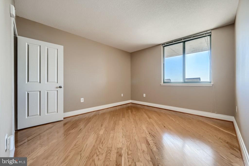 414 Water Street, Unit 2814 Baltimore, MD 21202 - Photo 11 of 28 a view of an empty room with wooden floor and a window