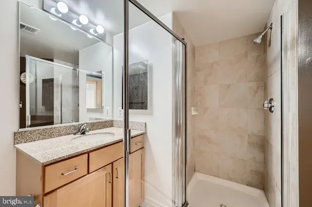 a bathroom with a shower sink and mirror