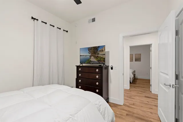 a bedroom with a bed and wooden floor