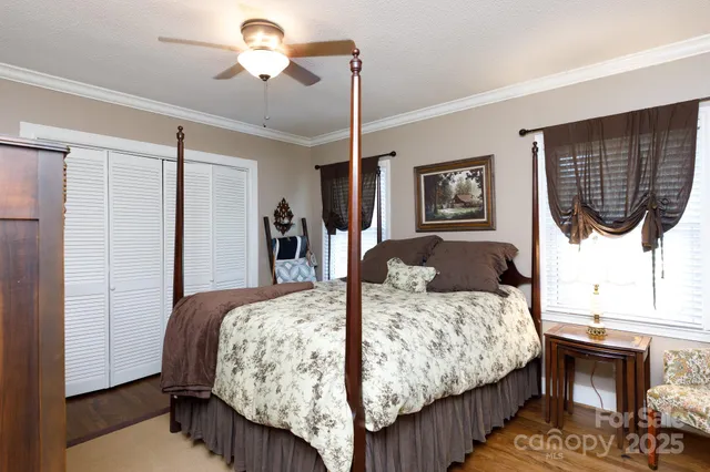 a bedroom with a bed a dresser and paintings