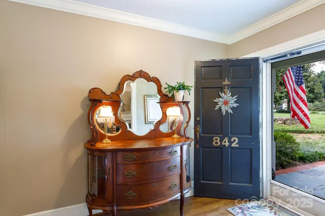 a room with painting on the wall and a potted plant