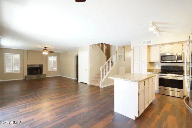 a kitchen with stainless steel appliances granite countertop a refrigerator a stove and a wooden floors