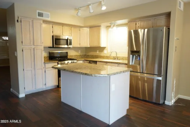 a kitchen with a refrigerator a microwave a sink and cabinets
