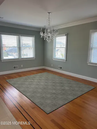 a living room with stainless steel appliances furniture a flat screen tv and a large window